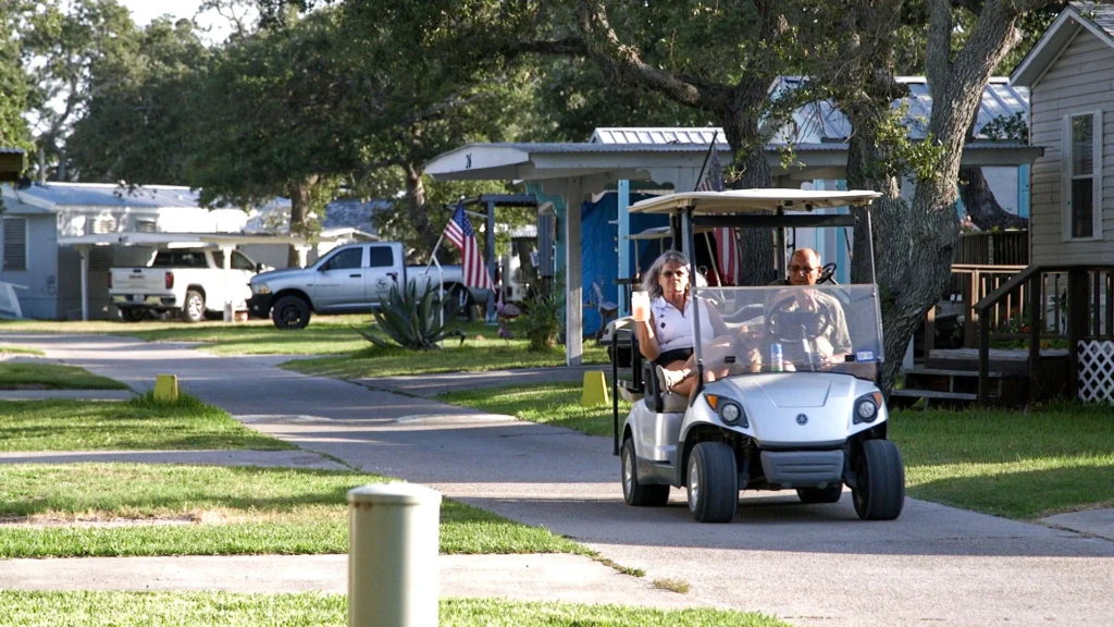 Two snowbird campers at Rockport RV Resort by RJourney drive a golf cart through the rv park in rockport, tx. 