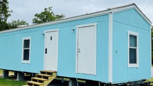A mobile building painted aqua blue at Sugar Valley RV Resort