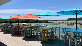 Tables with umbrellas on a patio at Coconut Cove RV Resort