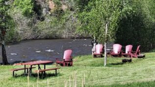 red lounge chairs near the river at Dolores River RV Resort