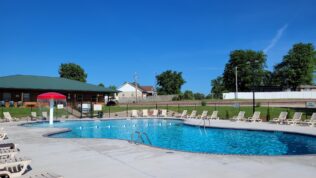 a pool next to a building at Perryville RV Resort