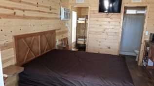 Large bedroom inside a rentable cabin at Dixie Forest RV Resort