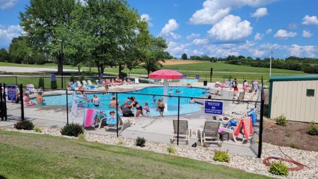 Family friendly swimming pool that is fenced in.