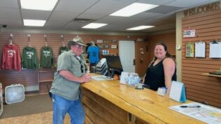 a man and a woman smiling at the camera at Laramie RV Resort in welcome center