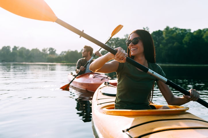 A man and woman kayaking on the lake.