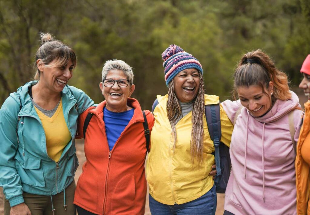 A group of women in winter clothing stand in a line outdoors