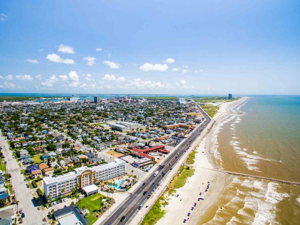 An aerial view looks down on the Galveston shoreline on a sunny day