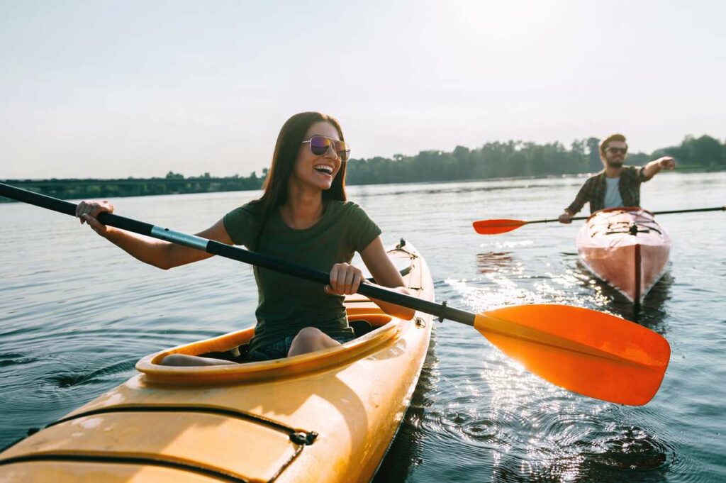 A man and woman kayak in open water