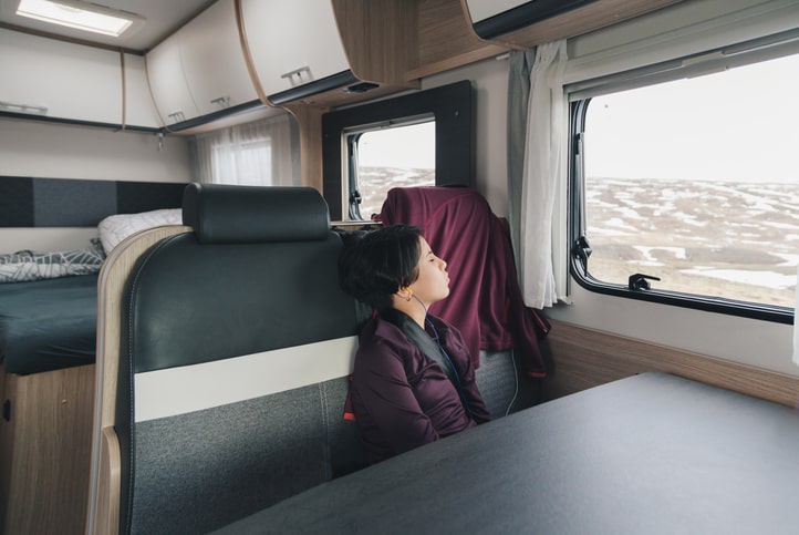 Person inside RV relaxing and listening to music.
