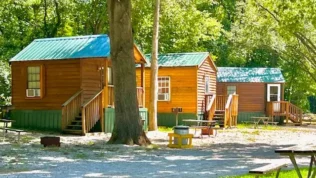 Three rental cabins with the sun shinning on them.