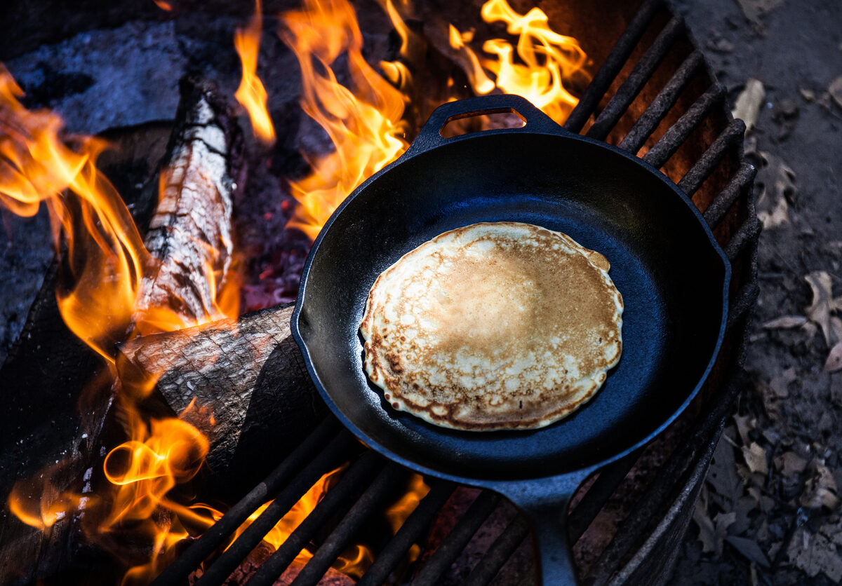 cooking a pancake over a campfire