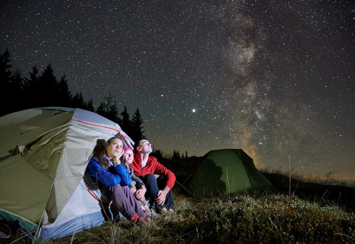 Campers sitting in a tent and stargazing.