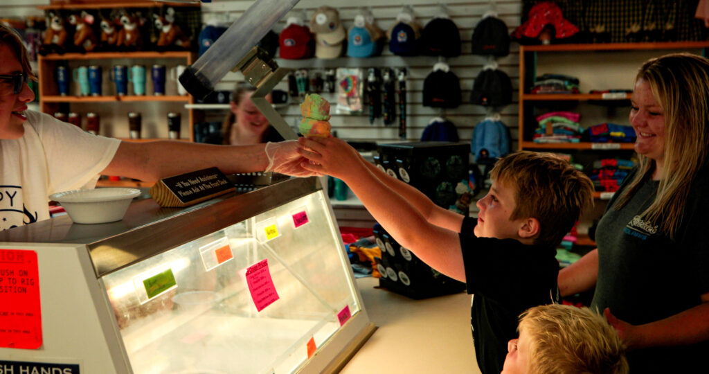 A boy gets an ice cream cone from the Snack Shack Restaurant at Baraboo RV Resort.