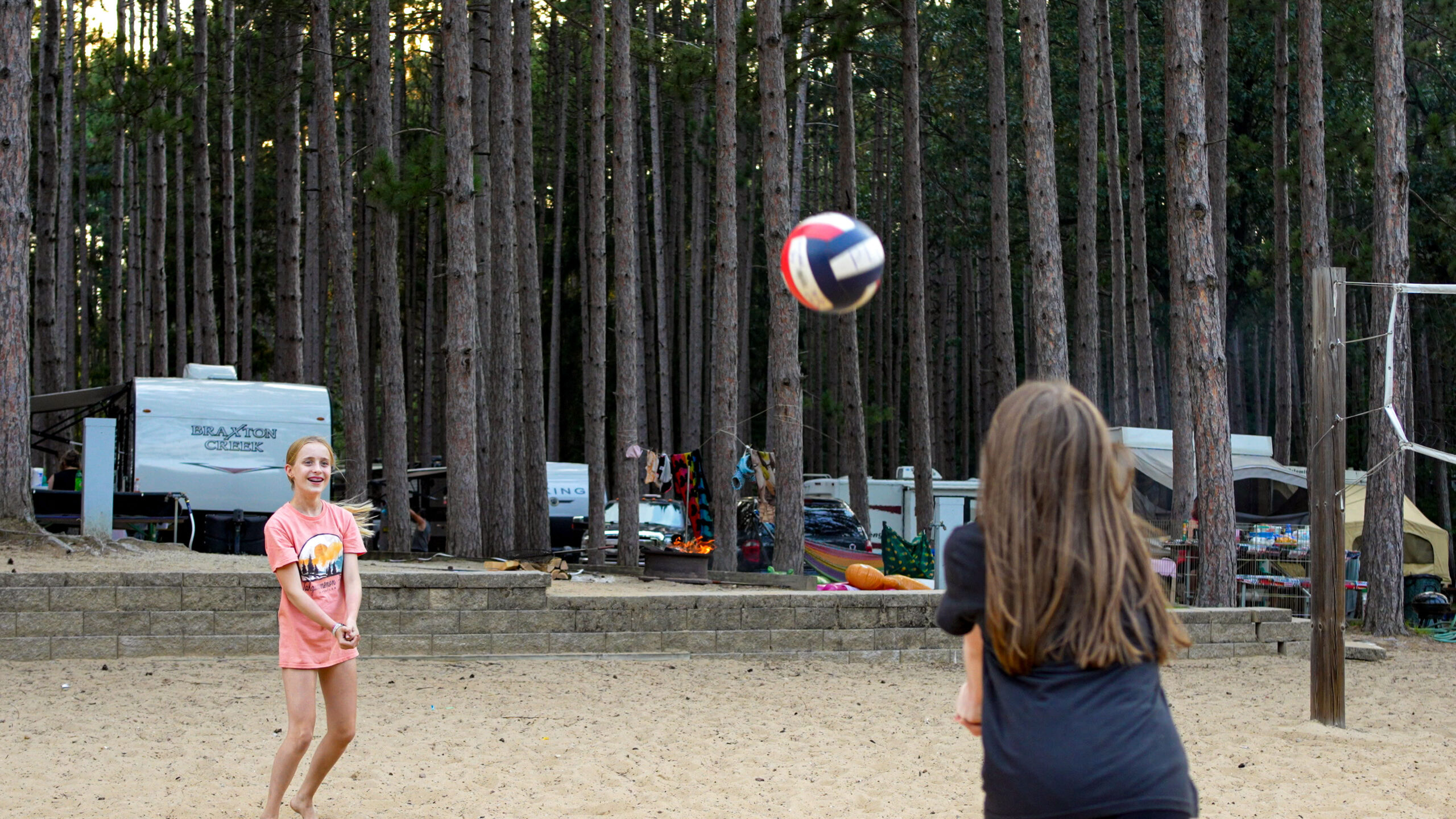 Kids play volleyball amongst the red pines at Pearl Lake RV Campground while camping near Redgranite WI