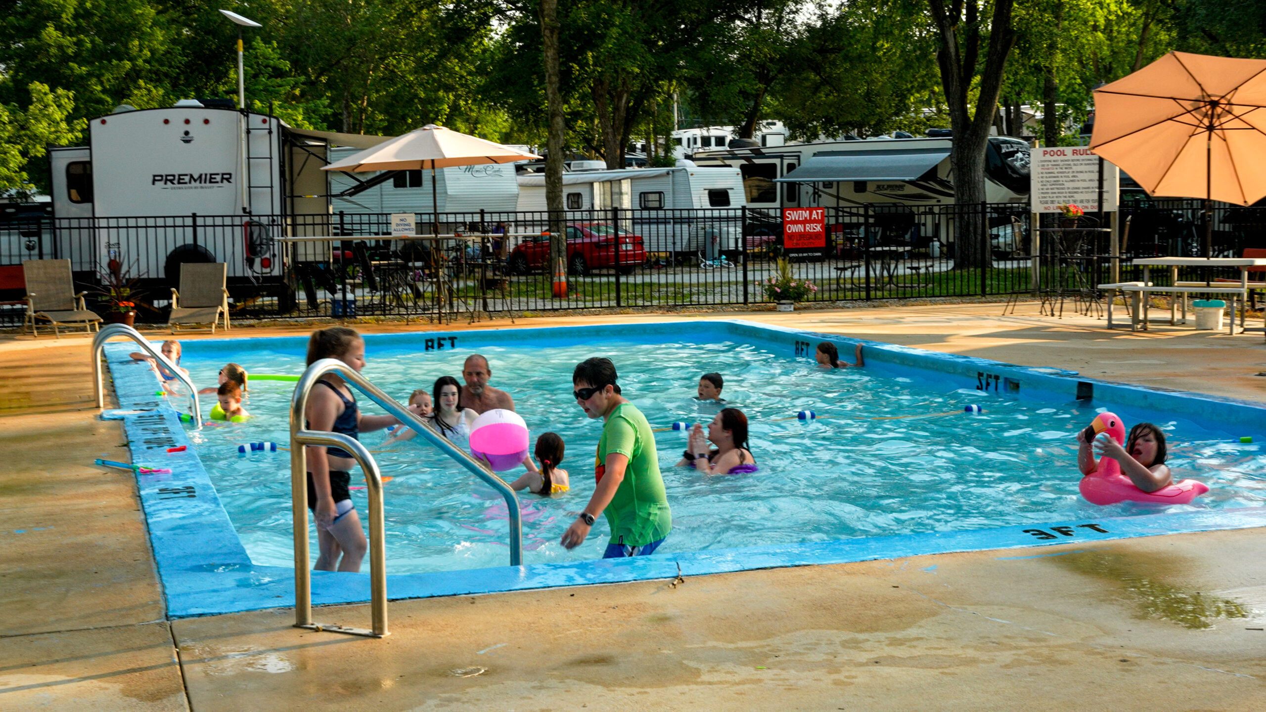 A view of the heated pool with RVs behind at Pin Oak RV Resort and Campround near Villa Ridge MO