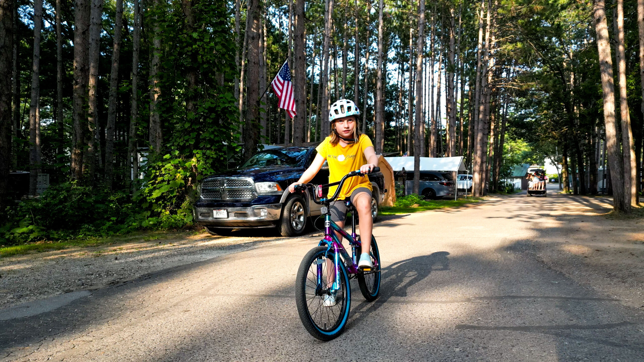 A girl rides her bikes amongst the pines at Pearl Lake RV Resort in Redgranite in central WI
