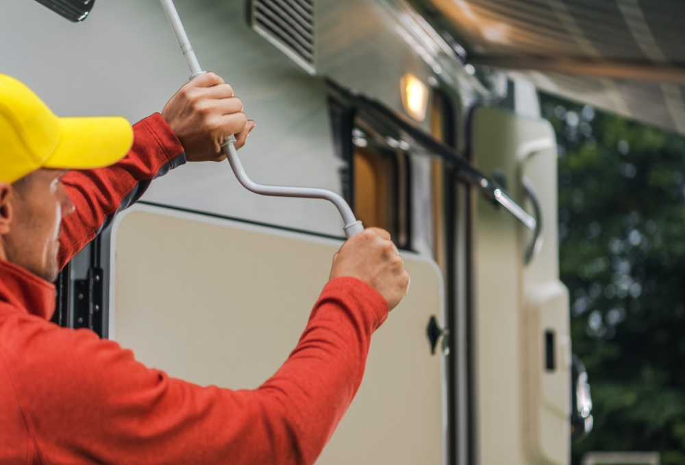 A man extends an awning on an RV