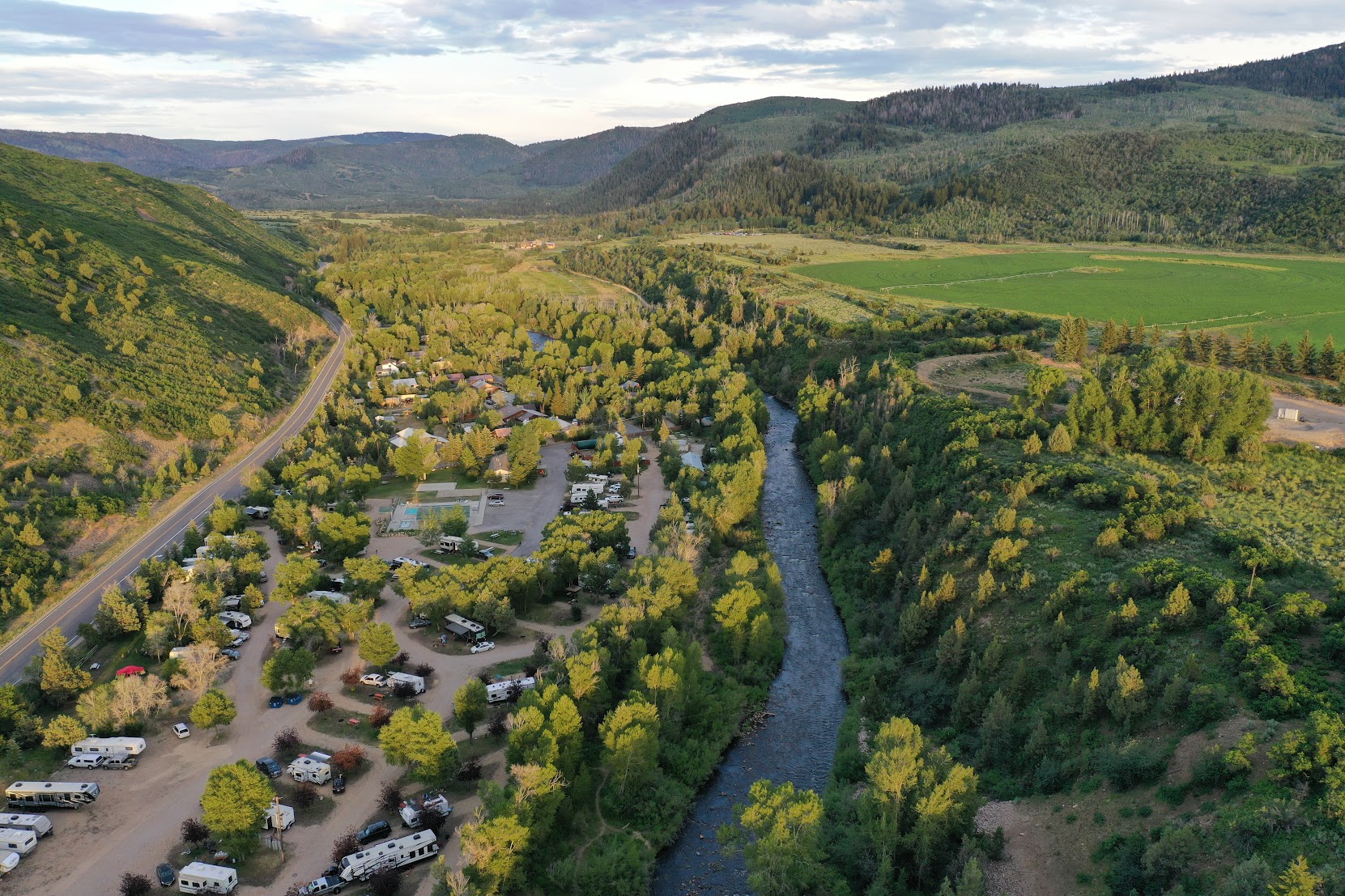 Riverside campsite at Roam Uinta RV Resort along the Provo River in Kamas, Utah, with the Uinta Mountains in the background