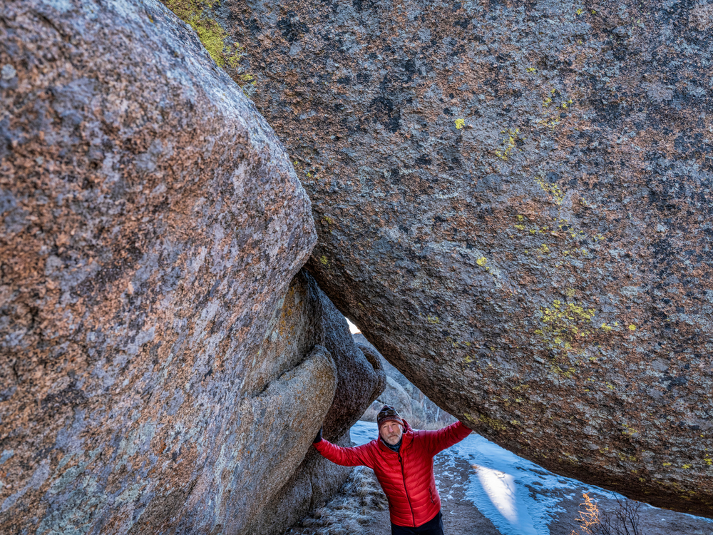 senior male hiker and granite rock formation in Vedauwoo Recreation Area, Wyoming,  known to the Arapaho Indians as Land of the Earthborn Spirit, winter scenery