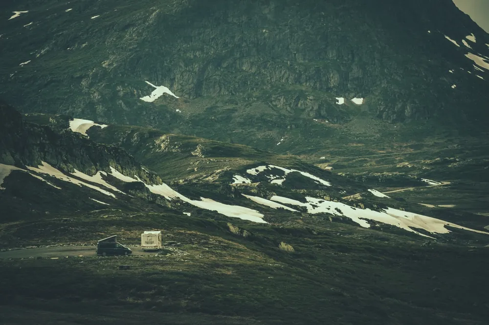 RV dry camping alone on a remote mountain pass dotted with patches of snow