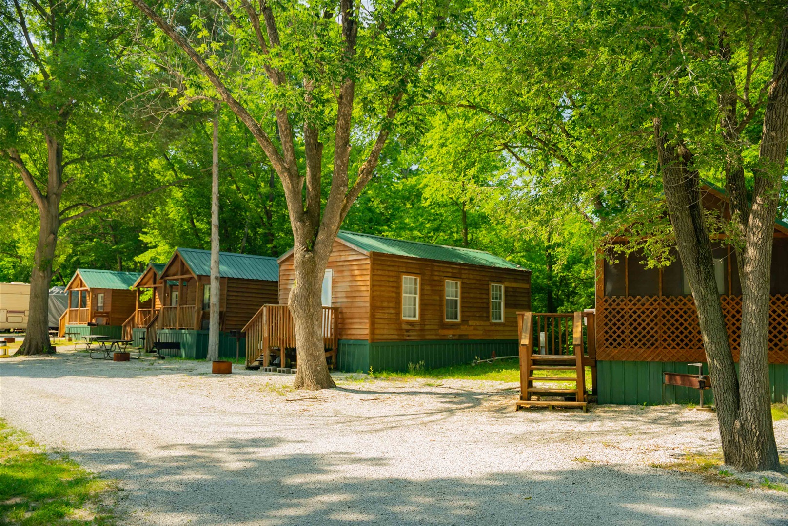Full-hookup RV sites set up for extended stays under mature shade trees at Pin Oak RV Resort near Villa Ridge, Missouri