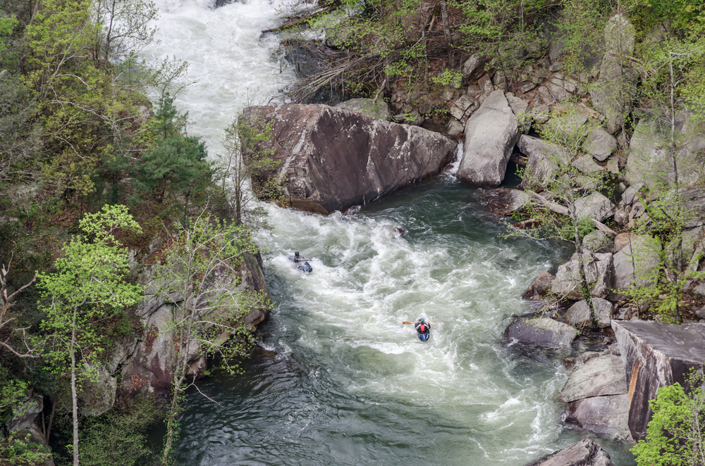 Kayakers paddle over rapids below Toccoa Falls near Lake Hartwell